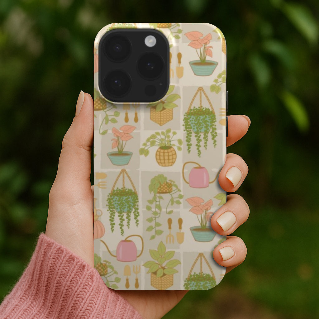 Hand holding a designer phone case with a plant lady pattern.