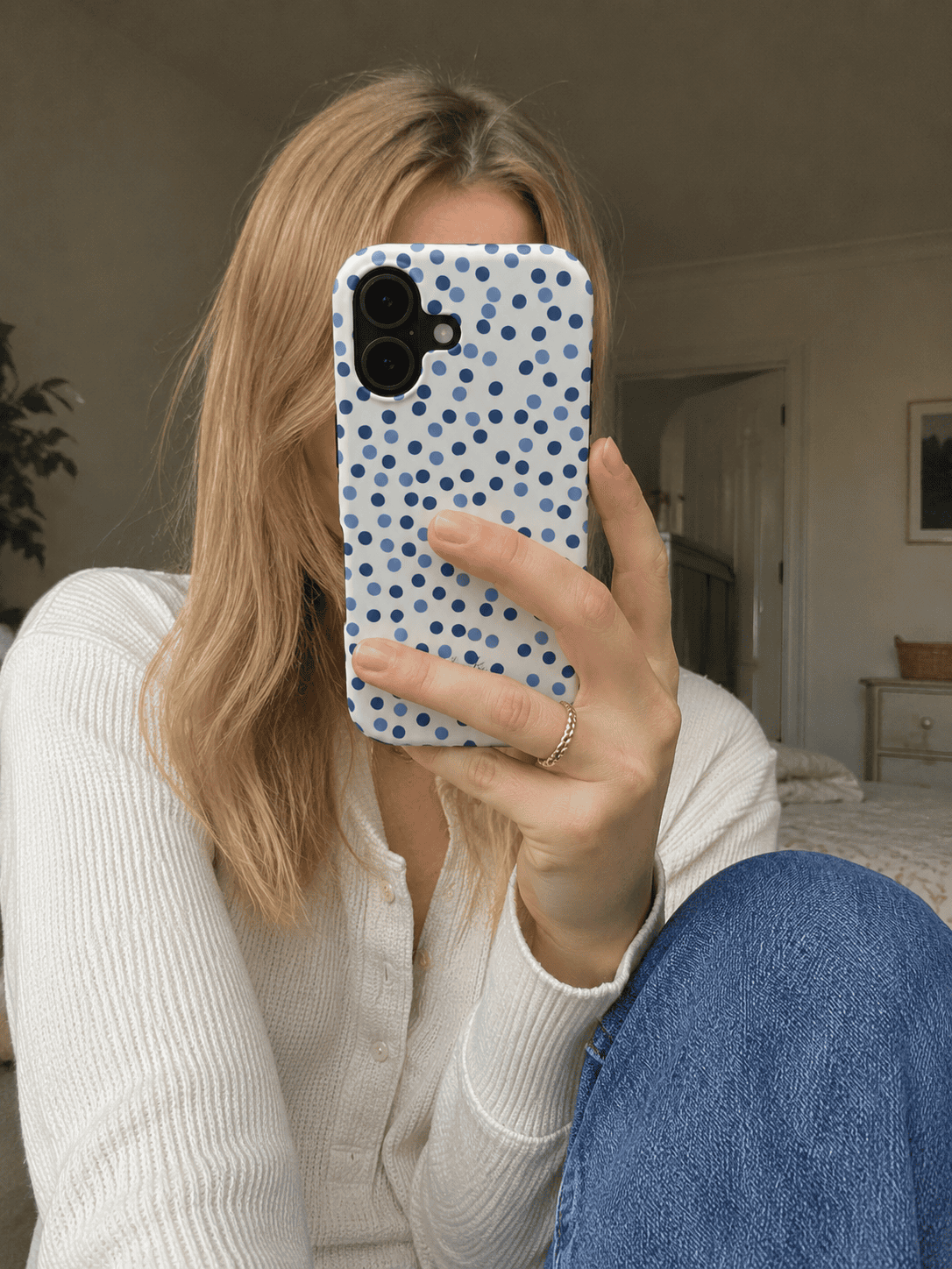 Tough phone case with a white background and blue polka dots. 