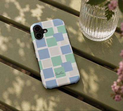 A phone case with a geometric checkered pattern in pastel blue, green, and white squares.