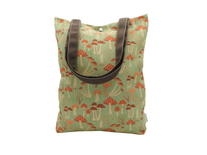 Mushroom canvas tote bag with brown handles, featuring a whimsical mushroom design on a blue-green background