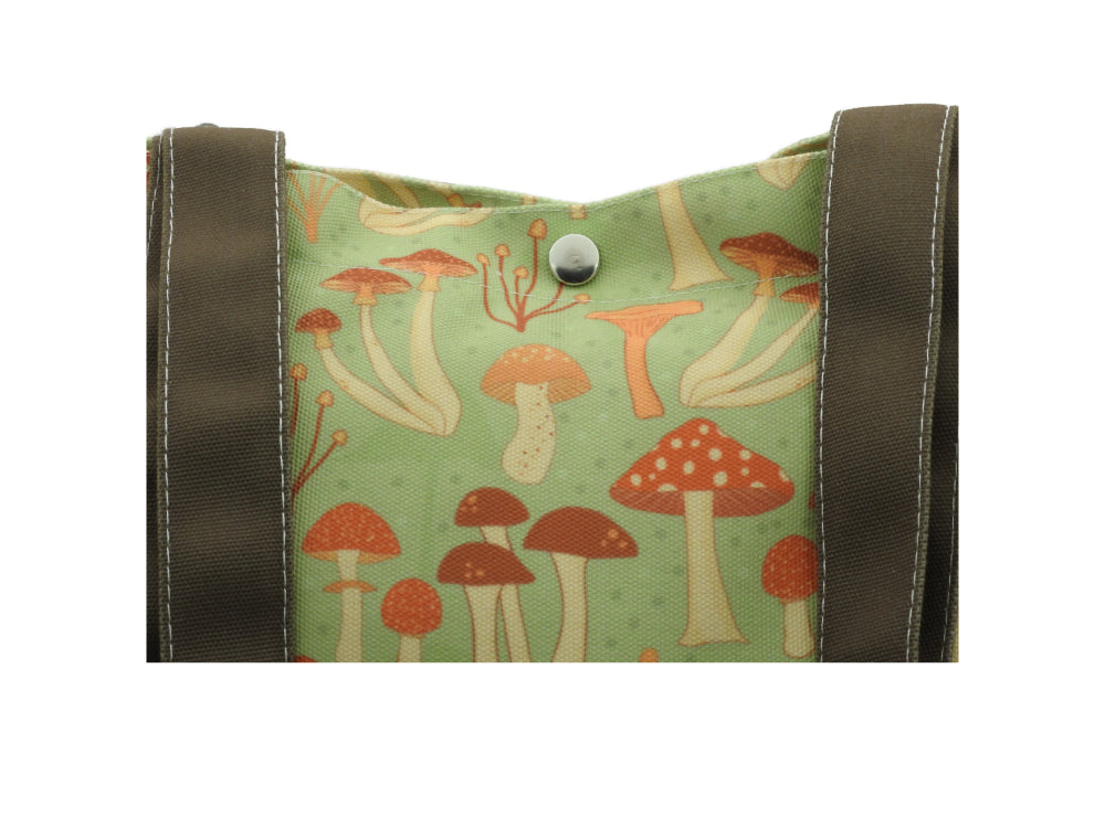 Mushroomcore canvas tote bag with brown handles, featuring a whimsical mushroom design on a blue-green background Closeup