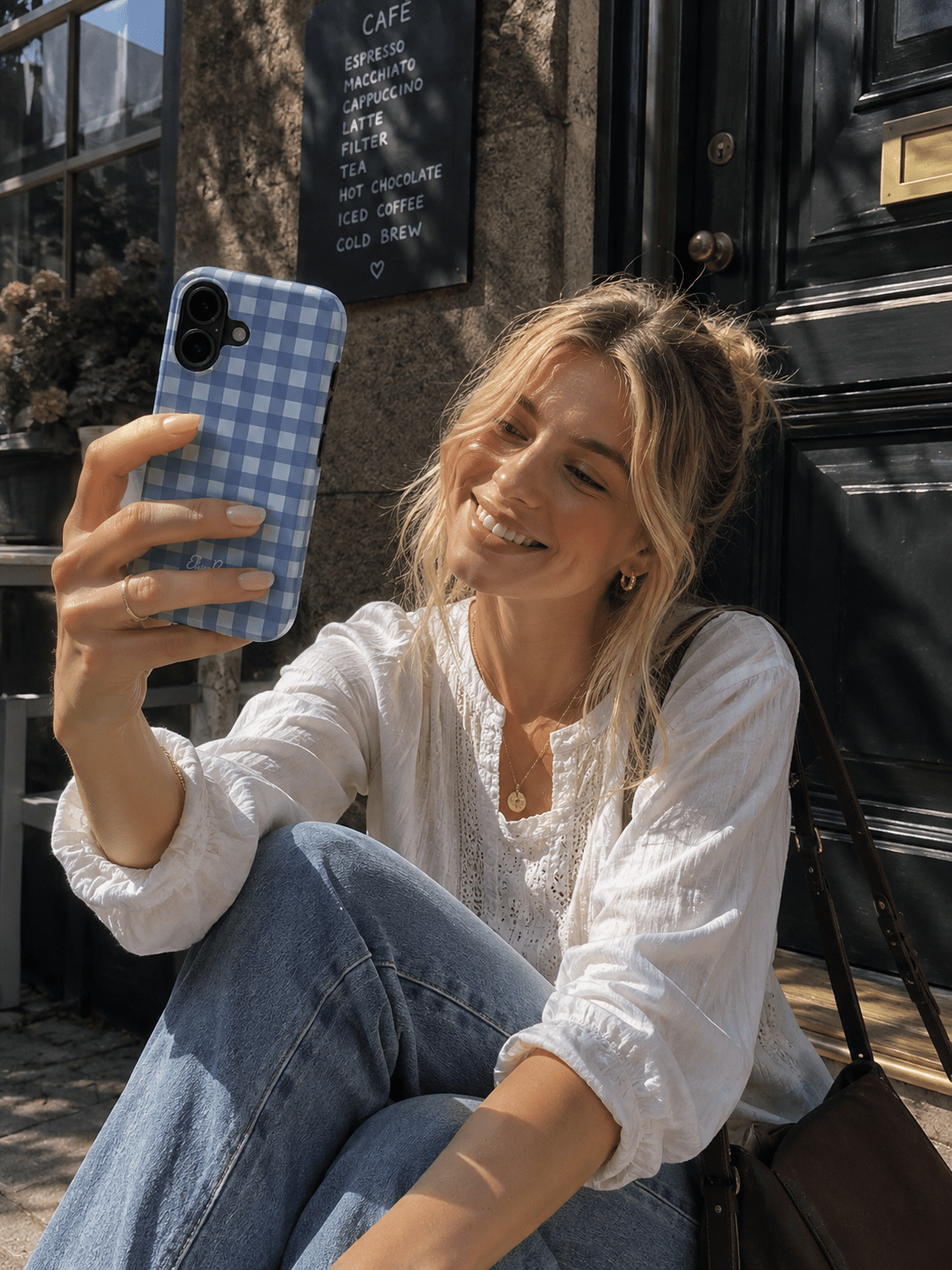Woman holding a blue gingham tough phone case