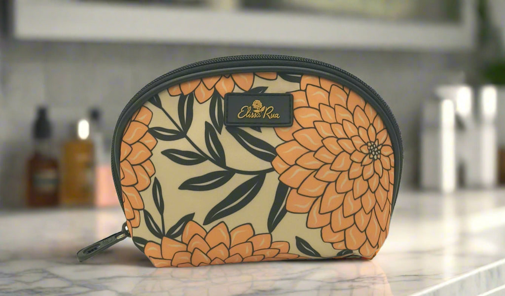 Dahlia cosmetic case with floral pattern by Elissa Rua, displayed on a marble bathroom countertop