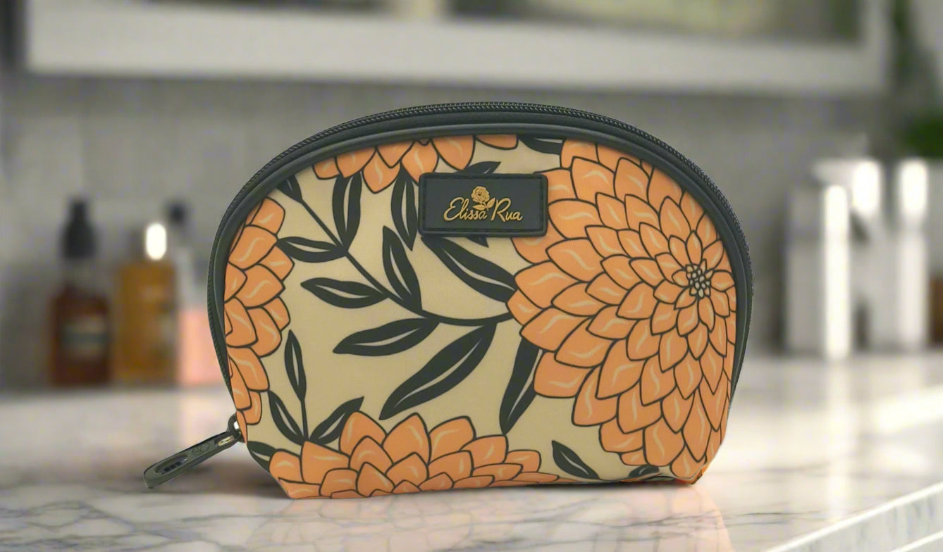 Dahlia cosmetic case with floral pattern by Elissa Rua, displayed on a marble bathroom countertop