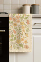 Floral Wilderness tea towel hanging in a kitchen setting, showcasing the botanical floral design in a real home environment.