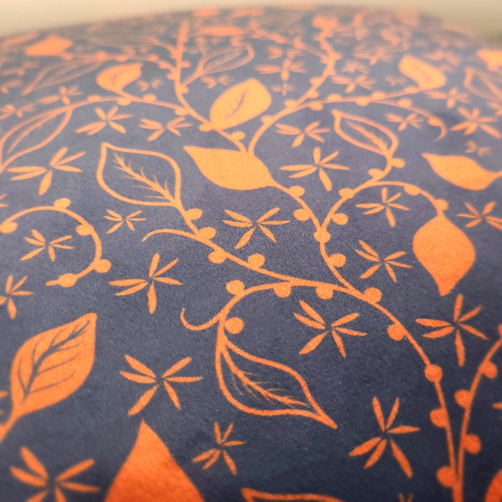 Close-up of navy and copper floral print on luxury velvet cushion cover
